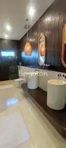 Modern Bali villa bathroom featuring stylish sinks, wooden accents, and contemporary lighting.