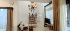 Bright living room featuring stylish furniture, warm lighting, and large windows for a welcoming atm.