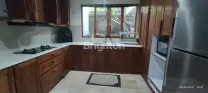 Kitchen with wooden cabinetry, large window, and stainless steel appliances in Villa Seuas.