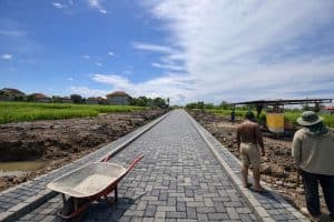 Newly constructed paved road in Pandak Gede, Tabanan for land development and building projects.