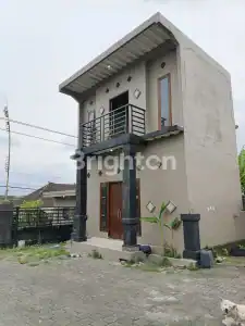 Contemporary concrete warehouse with balcony and large windows in Tabanan, Bali.
