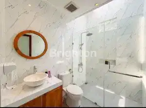 Luxury bathroom with modern fixtures and marble walls in a villa close to Nuanu Creative City.