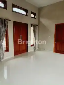 Spacious villa interior featuring wooden doors, high windows, and elegant curtains, perfect for rela.