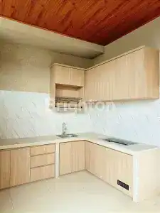 Modern kitchen with light wood cabinets and marble backsplash, perfect for relaxing beachside stays.