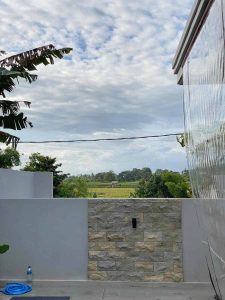 Modern villa view with lush greenery and sky in Bali.