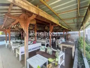 Rustic restaurant interior with wooden beams and cozy seating, located near Kerobokan, Bali.