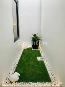 Small balcony garden with lush green grass and decorative white stones, perfect for relaxing near Pa.