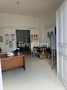 Modern office space with desks, chairs, and informational posters on the walls.